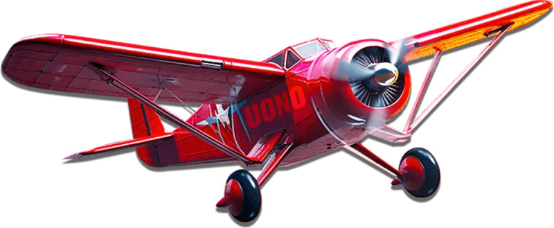 Red biplane banking above the clouds